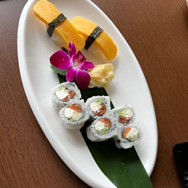 Spice Club's sushi platter with tamago nigiri, salmon and cream cheese rolls, ginger, and an orchid.